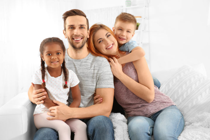 Happy interracial family sitting on sofa HIV Prevention Treatment Beaumont, TX